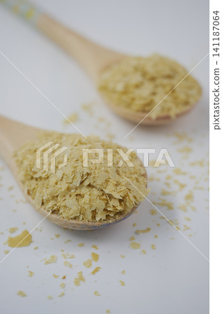 Nutritional yeast spread across wooden spoons in a kitchen Nutritional yeast spread across wooden spoons in a kitchen 141187064