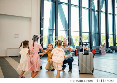 Family reunion at airport terminal welcoming children Family reunion at airport terminal welcoming children 141187068
