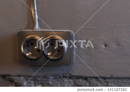 Double Electrical Socket Mounted on Gray Concrete Wall Close Up Double Electrical Socket Mounted on Gray Concrete Wall Close Up 141187382