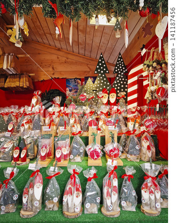 Paris, France - December 10, 2025: festive seasonal market stall displays handcrafted wooden Santa figures, Christmas tree ornaments, and Eiffel Tower decorations. Charming holiday souvenir setup Paris, France - December 10, 2025: festive seasonal market stall displays handcrafted wooden Santa figures, Christmas tree ornaments, and Eiffel Tower decorations. Charming holiday souvenir setup 141187456