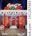 Chisinau, Moldova - January 10, 2026: A festive Coca-Cola themed house brightly decorated for Christmas with giant baubles, snowy eaves, and glowing lights. Magical winter holiday night background 141187483