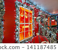 Chisinau, Moldova - January 10, 2026: a festive Coca-Cola booth facade decorated with frosted pine garlands and sparkling Christmas lights. Santa Claus holding a classic Coke bottle 141187485