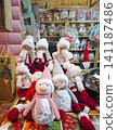 Chisinau, Moldova - January 10, 2026: Festive shop counter displays cute plush snowman dolls. Shelves filled with packaged holiday gifts create a cozy, charming atmosphere in a Christmas market booth 141187486