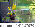 Vintage still life on an old chair with wildflowers and an old book. 141187679