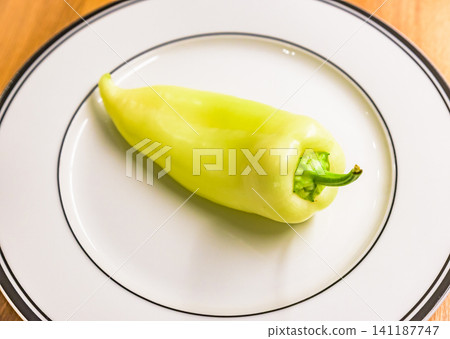 Fresh, light green Hungarian wax peppers (paprika) on a white plate. Fresh, light green Hungarian wax peppers (paprika) on a white plate. 141187747