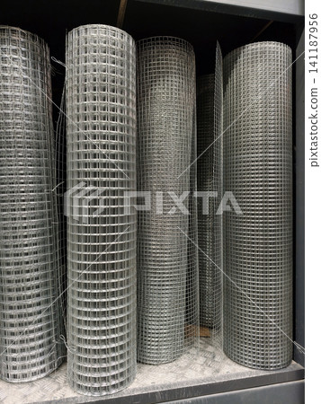 Welded fencing mesh prepared in cylindrical rolls and stored in a warehouse with construction materials Welded fencing mesh prepared in cylindrical rolls and stored in a warehouse with construction materials 141187956