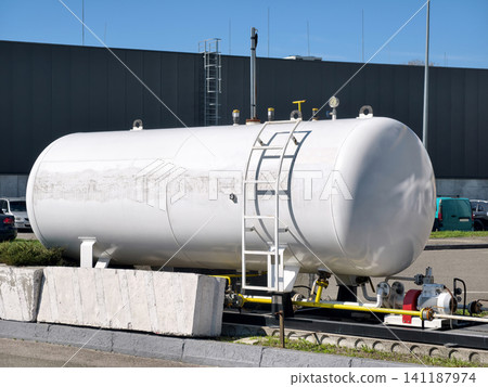 Liquefied gas storage tank with protective barrier and safety equipment at station 141187974