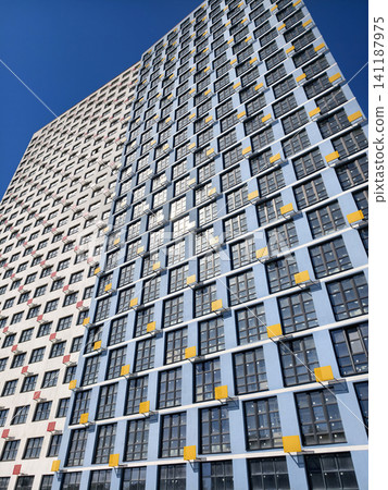 Facade of a newly built high-rise building, featuring air conditioner mounting systems, awaiting final touches 141187975