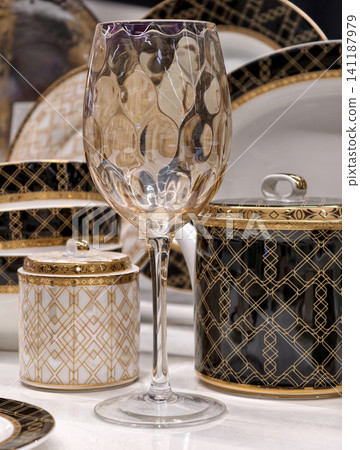 High end glass highlighted on a luxurious table setting with premium dining decor and elegant tableware behind High end glass highlighted on a luxurious table setting with premium dining decor and elegant tableware behind 141187979
