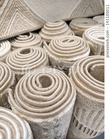 Soft home carpets rolled into large rolls displayed in a supermarket offering cozy flooring solutions for modern residential interiors Soft home carpets rolled into large rolls displayed in a supermarket offering cozy flooring solutions for modern residential interiors 141188011