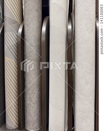 Wallpaper rolls in modern and classic patterns, neatly stacked on display shelves, offering a variety of options for any renovation project Wallpaper rolls in modern and classic patterns, neatly stacked on display shelves, offering a variety of options for any renovation project 141188063