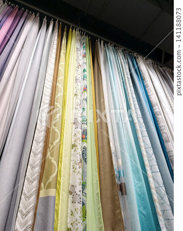 Brightly colored curtains in various styles hanging inside a store 141188073