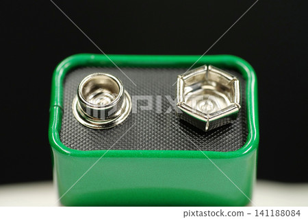 Green 9V battery simple composition, electric battery with connectors delivering nominal 9 volts and ready for powering electronic devices Green 9V battery simple composition, electric battery with connectors delivering nominal 9 volts and ready for powering electronic devices 141188084