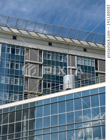 High rise residential tower with minimal facade and modern apartment balconies in urban district 141188093