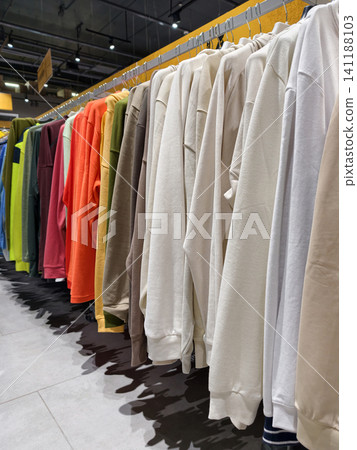 Range of vibrant hooded sweatshirts in a sporting goods environment highlights a practical and stylish selection of casual wear Range of vibrant hooded sweatshirts in a sporting goods environment highlights a practical and stylish selection of casual wear 141188103