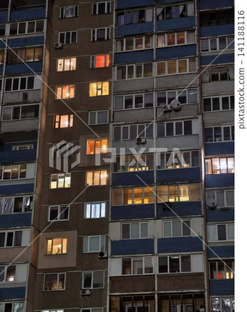 Night view of tall apartments in the city, windows glowing with light Night view of tall apartments in the city, windows glowing with light 141188116