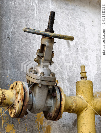 Gas control valve attached to the outer wall of residential architecture with yellow utility pipe and industrial infrastructure element Gas control valve attached to the outer wall of residential architecture with yellow utility pipe and industrial infrastructure element 141188138