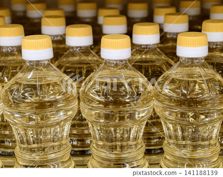 Sunflower cooking oil in vibrant yellow bottles ready for sale in supermarket Sunflower cooking oil in vibrant yellow bottles ready for sale in supermarket 141188139