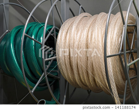 Green and transparent hoses wound into neat coils are available in a hardware store for general household and water use Green and transparent hoses wound into neat coils are available in a hardware store for general household and water use 141188174