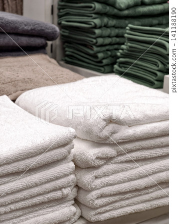 Neatly folded white soft towels on home products shelf in store Neatly folded white soft towels on home products shelf in store 141188190