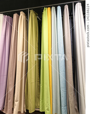 Vividly colored drapes in different styles hanging in a retail shop Vividly colored drapes in different styles hanging in a retail shop 141188224