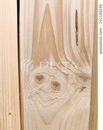 Wood texture on wooden board resembling funny fantasy creature with smiling face. Wooden material with natural wood marks creating cartoon creature face with happy smile Wood texture on wooden board resembling funny fantasy creature with smiling face. Wooden material with natural wood marks creating cartoon creature face with happy smile 141188246
