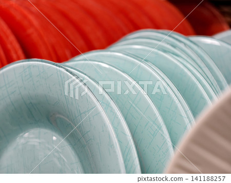 Beautiful light blue glass plates on shelves in supermarket, close up of tableware for kitchen and household use Beautiful light blue glass plates on shelves in supermarket, close up of tableware for kitchen and household use 141188257