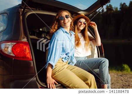 Two Young woman takes a selfie in the car during a road trip. Lifestyle, travel, tourism, nature. Two Young woman takes a selfie in the car during a road trip. Lifestyle, travel, tourism, nature. 141188478