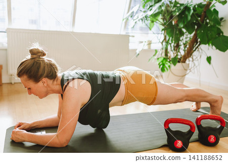 middle-aged woman doing Pilates at home 141188652