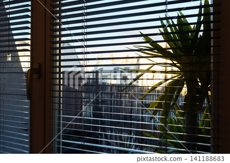 view from window sunset through blinds view from window sunset through blinds 141188683