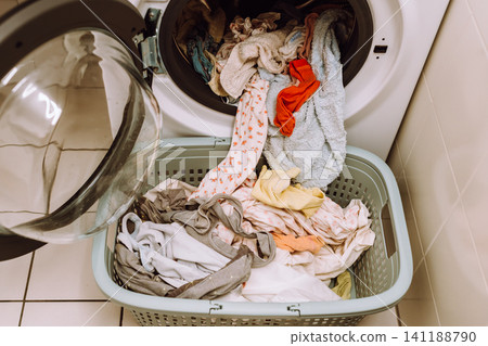 Place washed items from the washing machine into a basket Place washed items from the washing machine into a basket 141188790