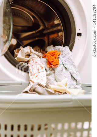 Place washed items from the washing machine into a basket Place washed items from the washing machine into a basket 141188794