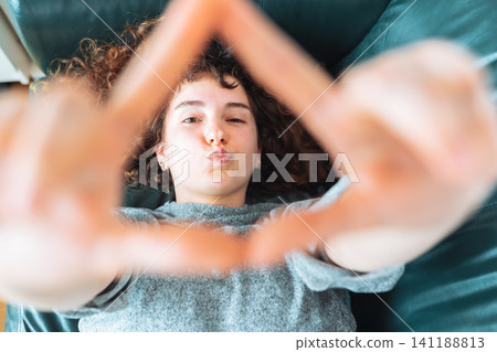young red-haired woman relaxing on leather sofa young red-haired woman relaxing on leather sofa 141188813