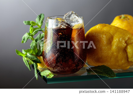 Cocktail with lemon wedges, ice and mint in misted glass. Cocktail with lemon wedges, ice and mint in misted glass. 141188947