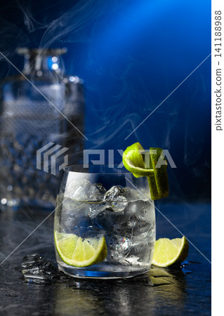 Vodka with lime and ice cubes in a fogged up glass. 141188988