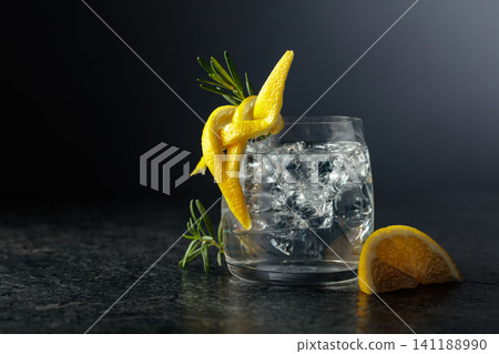 Gin and tonick cocktail in a fogged up glass on a black background. Gin and tonick cocktail in a fogged up glass on a black background. 141188990