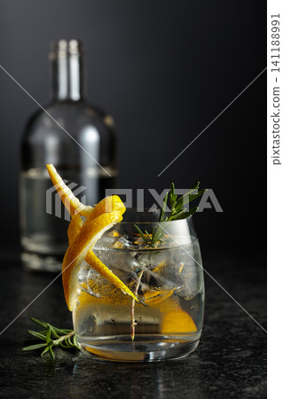 Gin and tonick cocktail in a fogged up glass on a black table. Gin and tonick cocktail in a fogged up glass on a black table. 141188991