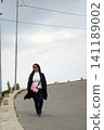 Stylish young woman walking on a winding mountain road in Darjeeling 141189002