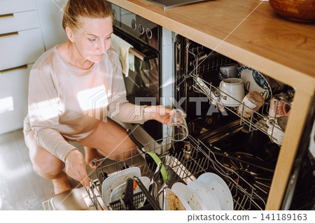 wash dishes in dishwasher 141189163