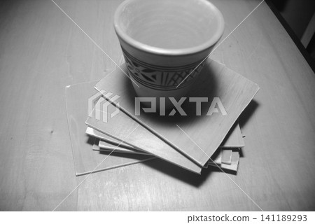 Clay cup placed on stack of ceramic tiles with terracotta handmade homeware Clay cup placed on stack of ceramic tiles with terracotta handmade homeware 141189293