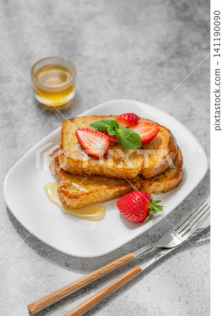 Brioche toasts with strawberry and honey on a plate on a concrete background Brioche toasts with strawberry and honey on a plate on a concrete background 141190090