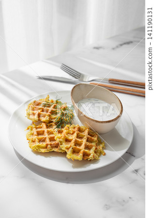 Vegetarian potato waffles with natural yogurt and dill on a plate on a marble background Vegetarian potato waffles with natural yogurt and dill on a plate on a marble background 141190131