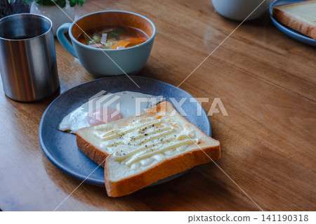 A breakfast set consisting of warm soup, a fried egg, and toast. A breakfast set consisting of warm soup, a fried egg, and toast. 141190318