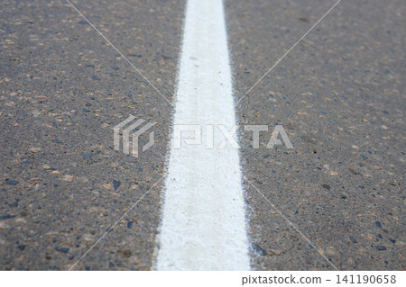 Fresh white solid road markings on a city asphalt street. New road markings in the city nfrastructure. Fresh white solid road markings on a city asphalt street. New road markings in the city nfrastructure. 141190658