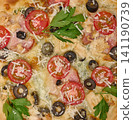 Close-up of delicious pizza with tomato, olive, bacon, chicken, grated cheese and parsley 141190739