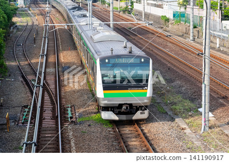 [Tokaido Line] A train speeds through the town of Omori in the early morning. 141190917
