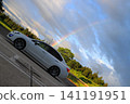 A car and a rainbow in the sky. A car and a rainbow in the sky. 141191951