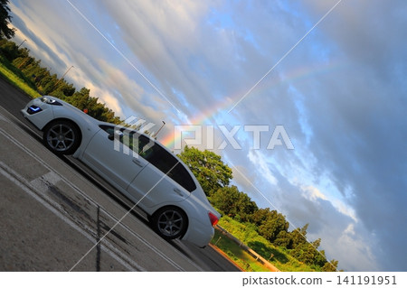一輛汽車和天空中的彩虹。 一輛汽車和天空中的彩虹。 141191951