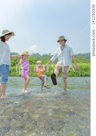 A family of four playing in the river in summer. A family of four playing in the river in summer. 141192026