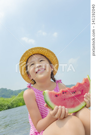 夏天,一個女孩在河邊吃西瓜。 夏天,一個女孩在河邊吃西瓜。 141192040